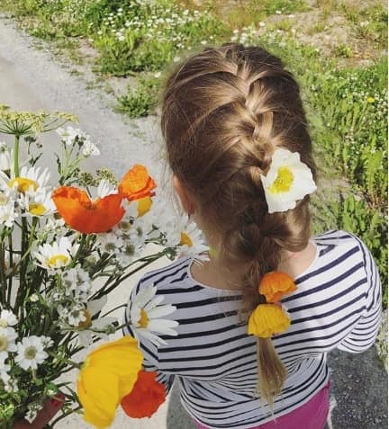 Center Parted Hairstyle With Braided Ponytail And Flowers