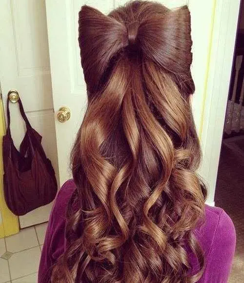 Combed Back Hairstyle With Statement Bow And Wavy Back