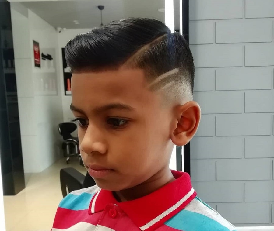 boy's side part fade hair with design
